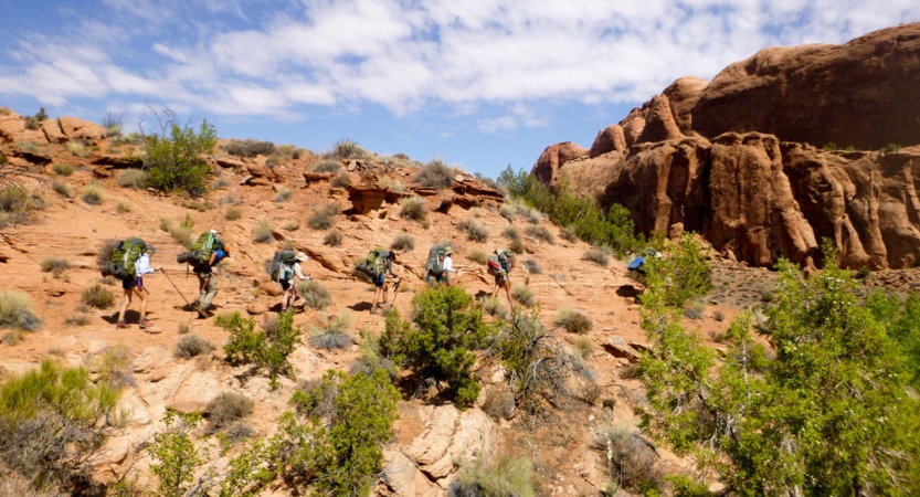 a group of outward bound gap year students make their way across a desert landscape